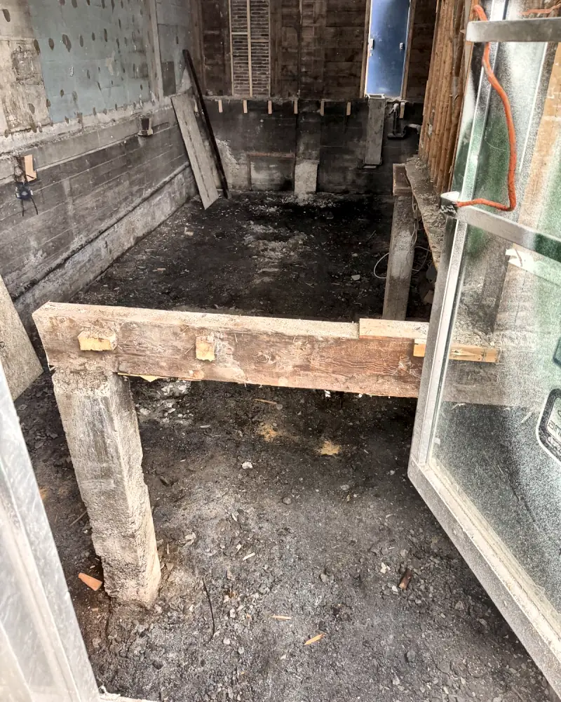 Poutre et poteau de bois dégagés au sous-sol d’un local commercial