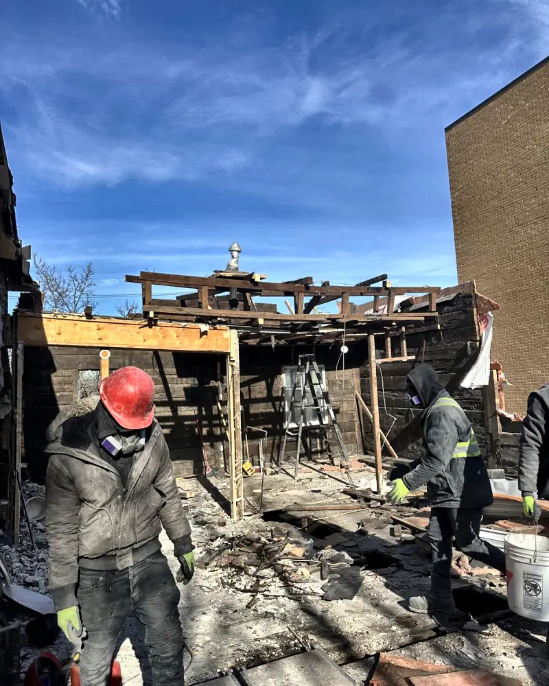 The crew demolishing a rear addition down to the framing