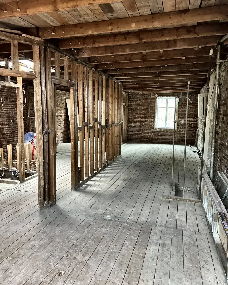 Whole floor stripped to the structure, brick wall at the back